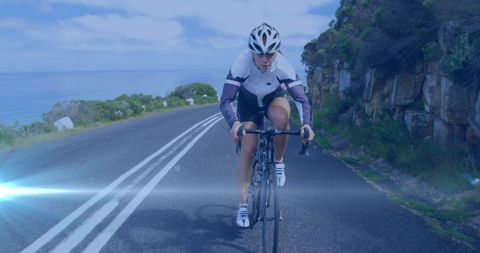 Caucasian Female Cyclist Enjoying Scenic Road on Sunny Day