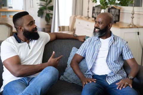 African American Father and Son Connecting on Modern Gray Sofa