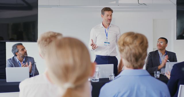 Businessman Leading Meeting with Colleagues Applauding in Conference Room - Download Free Stock Images Pikwizard.com