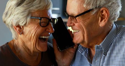 Senior Couple Sharing Joyful Moment on Phone Call Together
