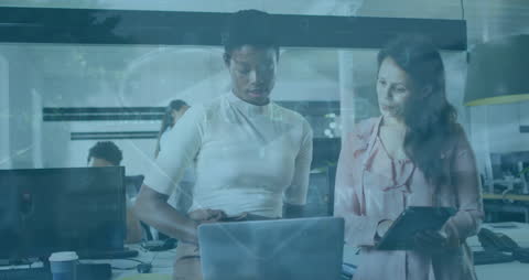 Diverse Coworkers Collaborating on Digital Reports in Modern Office