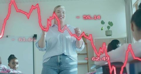 Female teacher presenting lesson with declining red graph overlay in classroom