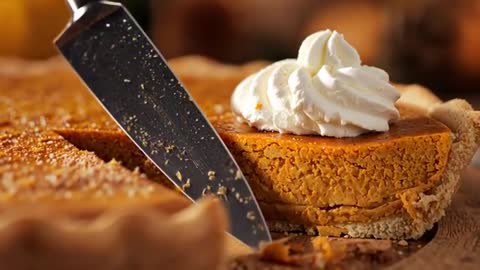 Cutting Pumpkin Pie Slice with Knife and Serving Whipped Cream Topped Slice, Rustic Closeup