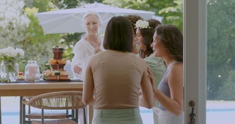 Joyful Females Sharing Laughter at Poolside Wedding Celebration