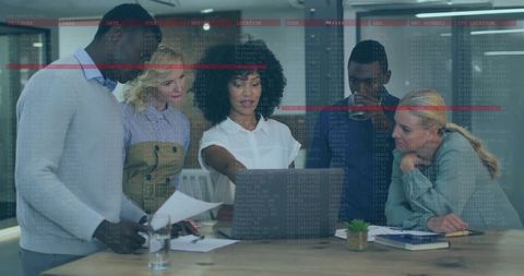 Diverse Team Collaborating Around Laptop Analyzing Cybersecurity Data Visualization