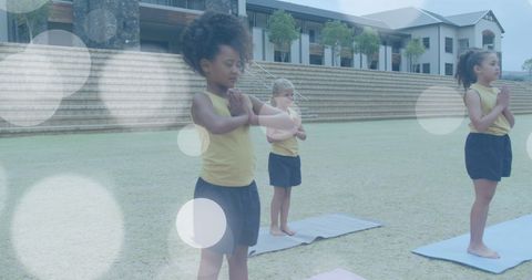 Children practicing yoga outdoors on a sunny day