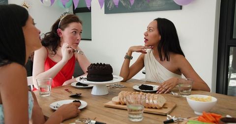 Diverse friends celebrating birthday with cake and conversation