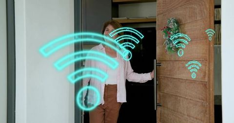 Senior woman holding smart door handle with holographic wi-fi icons welcoming home