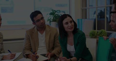Female facilitator leading small team meeting in modern office for collaborative brainstorming