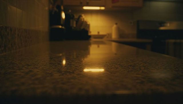 Polished granite countertop reflecting warm under-cabinet lights in cozy home kitchen
