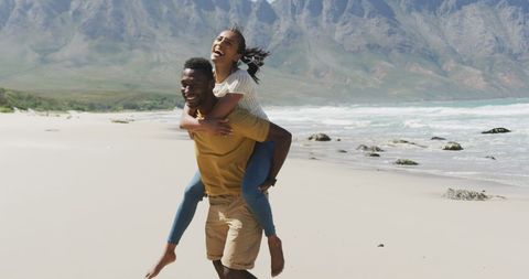 Happy Couple Enjoying a Playful Beach Piggyback Ride