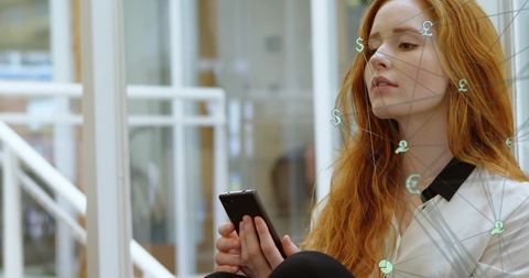 Young red-haired businesswoman using smartphone while digital financial symbols and network overlay illustrate global connectivity and communication. Ideal for portraying concepts of modern entrepreneurship, fintech, technology-driven businesses, and global economic trends. Perfect for articles, presentations, or web content related to innovation, finance, and digital communication.