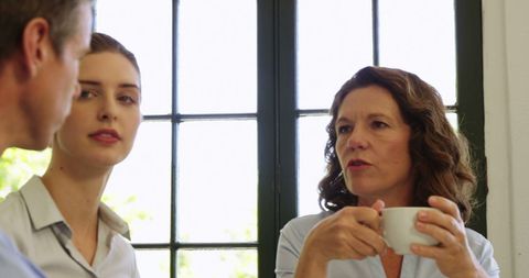 Business Team Discussing Over Coffee in Restaurant
