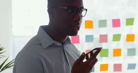 Young Businessman Communicating via Mobile Phone in Modern Office