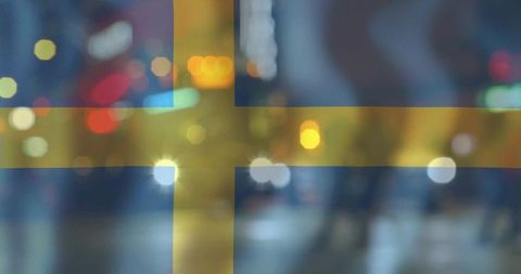 Swedish flag over blurred night street with bokeh lights, headlights, urban silhouettes