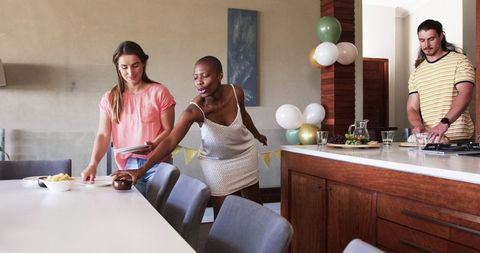 Friends Preparing for Celebration Setting Dining Table