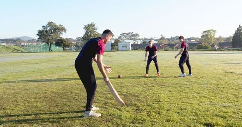 Energetic Teenagers Enjoying Outdoor Cricket Practice on Sunny Day