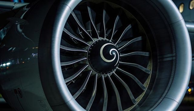 Night close-up showing turbofan engine inlet, fan blades and spinner spiral under lights