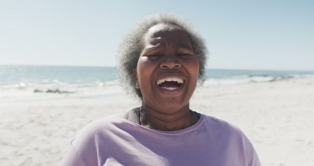 Joyful Elderly Woman Laughing on Sunny Beach - Download Free Stock Images Pikwizard.com