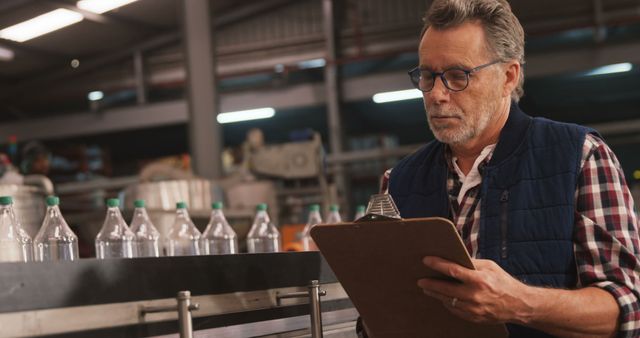 Senior Male Quality Inspector Evaluating Bottles in Factory - Download Free Stock Images Pikwizard.com