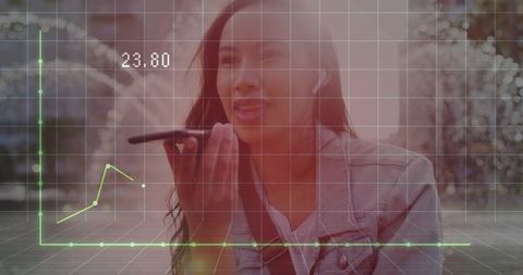 Young woman speaking into smartphone with hud financial graph overlay and urban bokeh