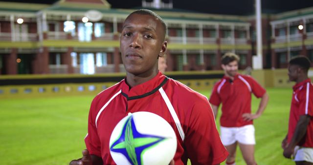 Young Athlete Holding Rugby Ball on Field at Night - Download Free Stock Images Pikwizard.com