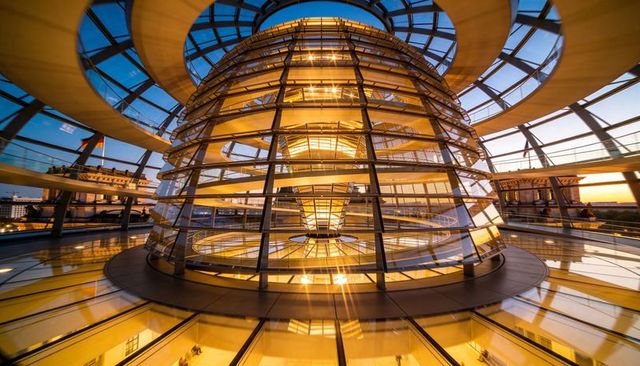 Glowing reichstag glass dome embracing golden light with spiral walkways and symmetry