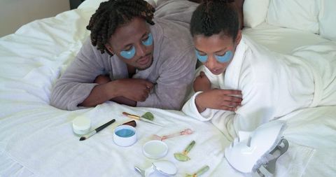 African american couple enjoying at-home spa night wearing blue under-eye patches