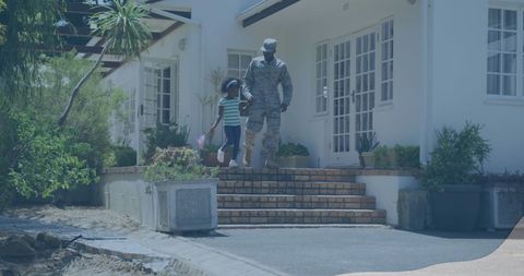 Military Parent Holding Hands with Child on Suburban Street