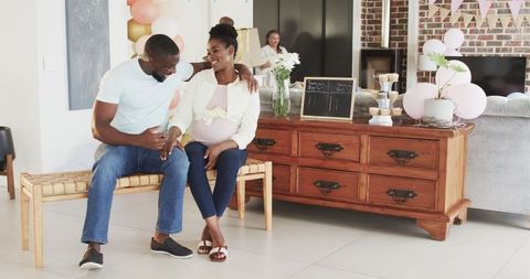 Joyful expecting parents celebrating baby shower together