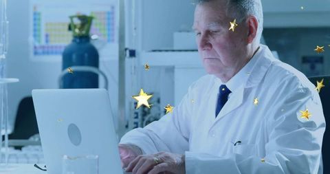 Focused senior scientist at laboratory laptop with gas cylinder