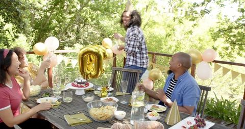 Diverse Group Celebrating Birthday on Sunny Outdoor Terrace