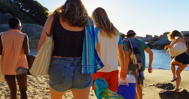 Friends Enjoying Beach Day with Cooler and Towels by Ocean - Download Free Stock Images Pikwizard.com