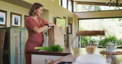 Pregnant Woman Unpacking Groceries in Cozy Modern Kitchen
