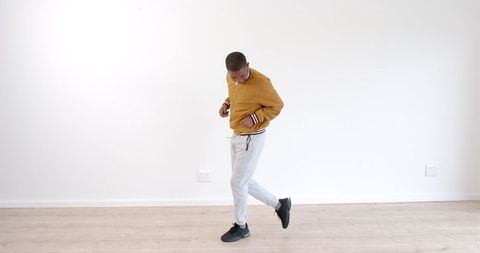 Young Man Expressing Joyful Dance Moves in Casual Outfit