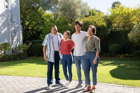 Happy Family Standing on Path in Green Backyard
