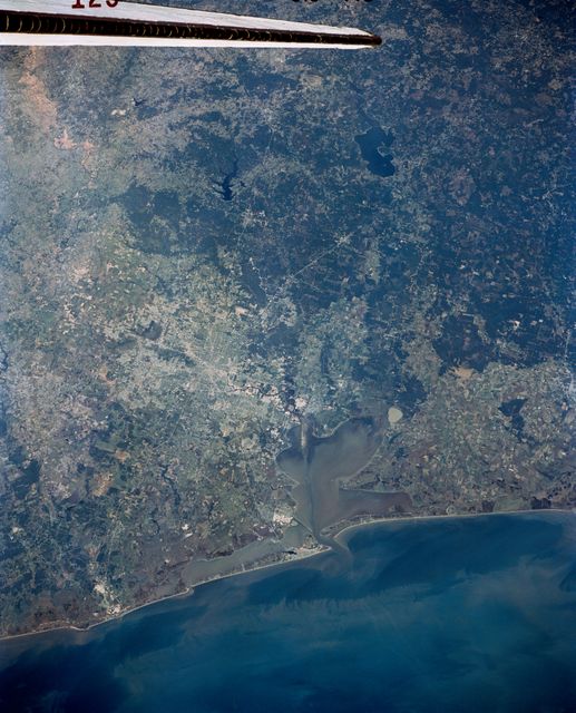 Stunning satellite view of Houston, Texas and surrounding areas showing the Houston Ship Channel, Clear Lake, and detailed infrastructure. Useful for educational materials, presentations on urban development, geography studies, or documentaries on space exploration and satellite imaging.