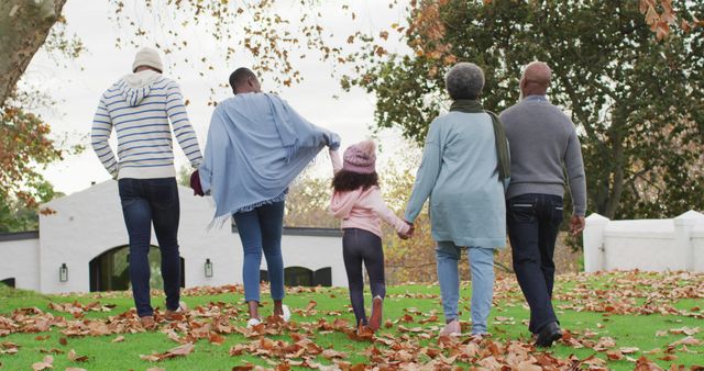Image of rear view of african american parents and grandparents and granddaughter walking in garden. Family, domestic life and togetherness concept digitally generated image.