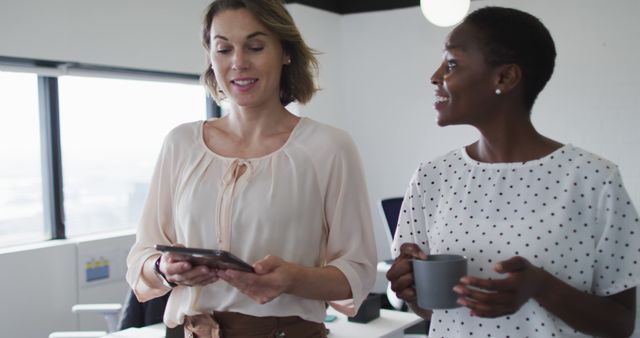 Two Businesswomen Talking with Digital Tablet in Modern Office - Download Free Stock Images Pikwizard.com