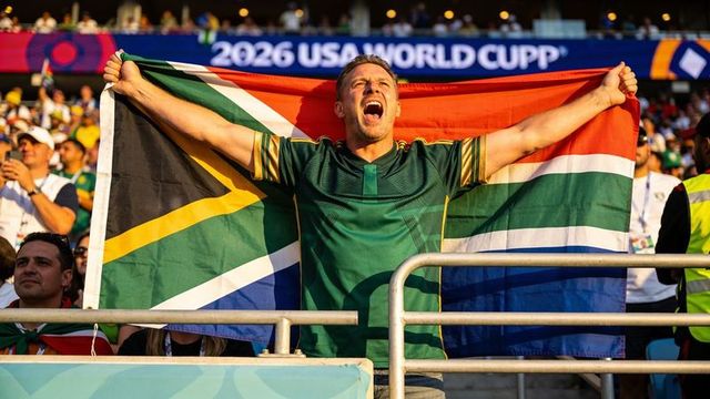 South african fan waving flag and cheering in stadium during 2026 world cup celebration