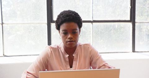 African american businesswoman concentrating on laptop task in office