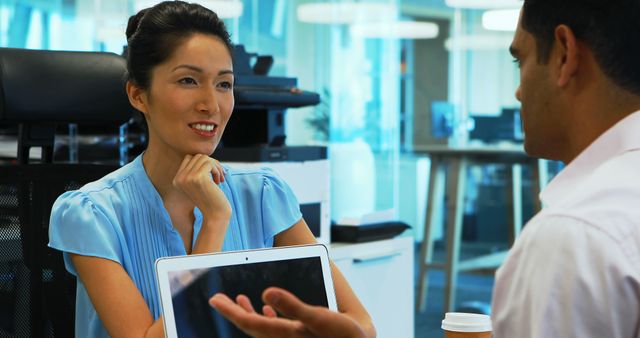 Smiling Businesswoman in Discussion with Colleague at Office Desk - Download Free Stock Images Pikwizard.com