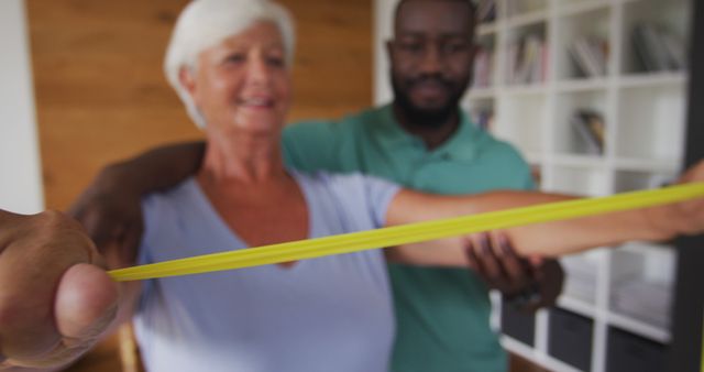 Senior woman exercising with caregiver assistance using resistance band - Download Free Stock Images Pikwizard.com