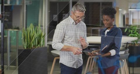 Diverse Professionals Discussing Documents in Modern Workspace