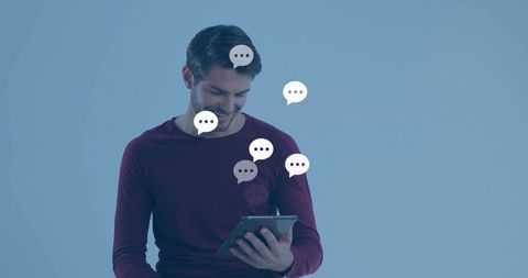 Man reading tablet surrounded by chat bubbles, messaging concept for mobile