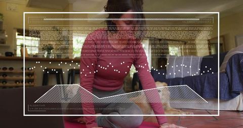 Woman practicing yoga at home on pink mat with laptop and dog, using virtual fitness hud