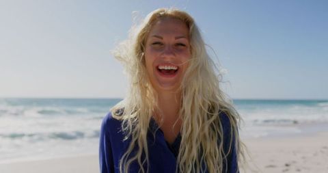 Joyful Woman with Blonde Hair Smiling at Sunny Beach