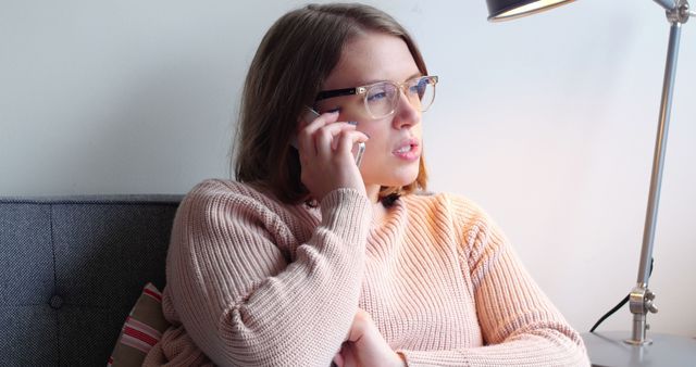 Woman with Glasses Talking on Smartphone Sitting on Couch - Download Free Stock Images Pikwizard.com