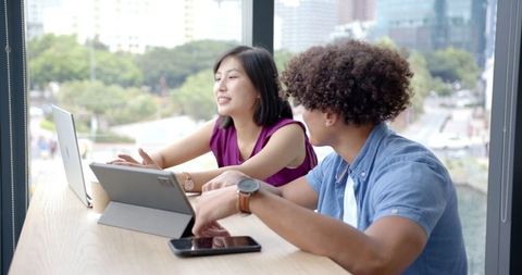 Colleagues Collaborating with Tablets in Modern Office Setting