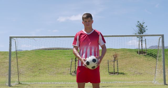 Determined Soccer Player Holding Ball in Front of Goal on Field - Download Free Stock Images Pikwizard.com